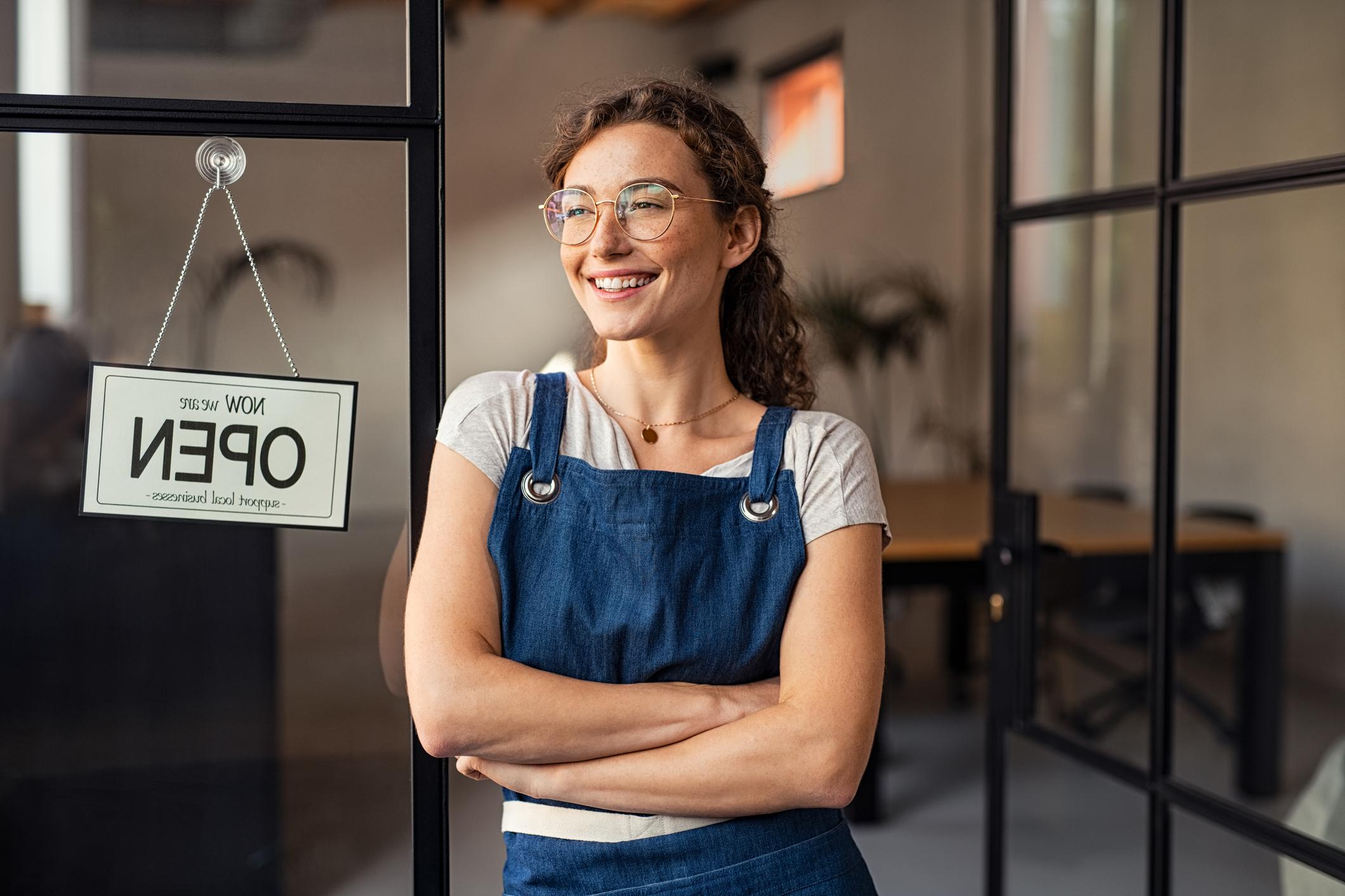 woman with folded arms looking outside of store